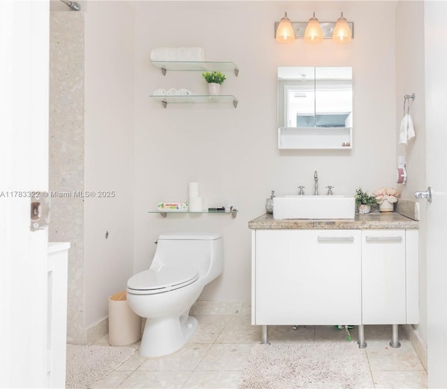 full bathroom featuring toilet, tile patterned floors, vanity, and baseboards
