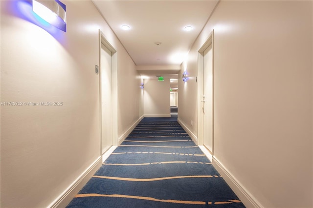 hall with baseboards and carpet floors