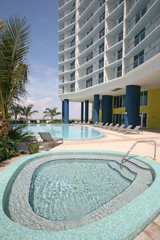 community pool featuring a patio area and a hot tub
