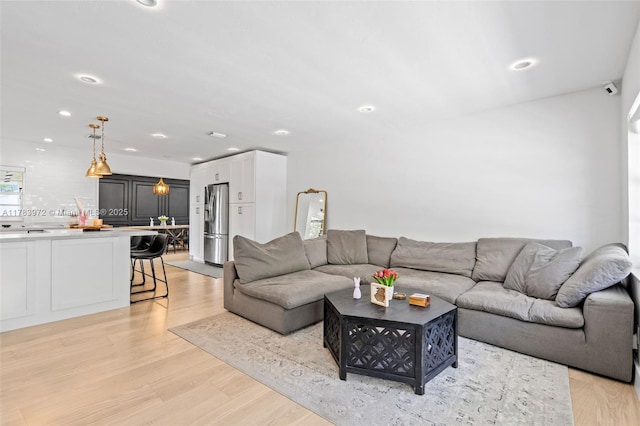 living room with light wood finished floors and recessed lighting