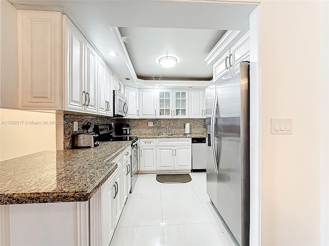 1913 S Ocean Dr Unit 110, Hallandale Beach, FL 33009 - kitchen with stainless steel appliances, light tile patterned flooring, white cabinetry, backsplash, and a raised ceiling