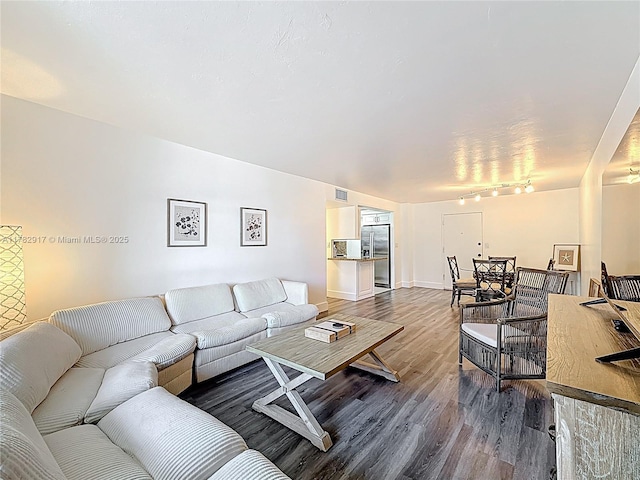 1913 S Ocean Dr Unit 110, Hallandale Beach, FL 33009 - living area with visible vents, baseboards, wood finished floors, and rail lighting