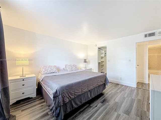 1913 S Ocean Dr Unit 110, Hallandale Beach, FL 33009 - bedroom with visible vents, baseboards, wood finished floors, a closet, and a walk in closet