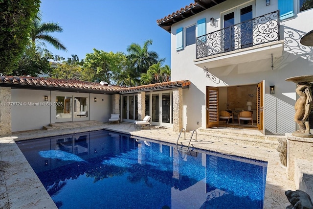 551 S Mashta Dr, Key Biscayne, FL 33149 - rear view of house with a balcony, an outdoor pool, a tiled roof, a patio, and stucco siding