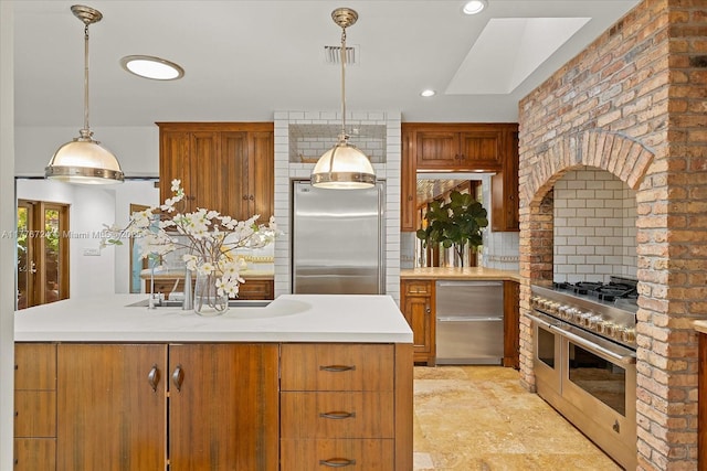 551 S Mashta Dr, Key Biscayne, FL 33149 - kitchen featuring visible vents, brown cabinets, light countertops, appliances with stainless steel finishes, and hanging light fixtures