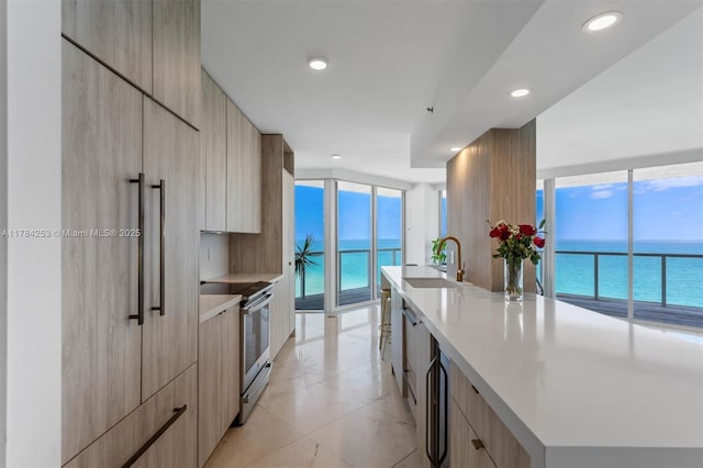 7330 Ocean Ter Unit 20-B, Miami Beach, FL 33141 - kitchen featuring modern cabinets, a sink, light brown cabinets, and stainless steel electric stove