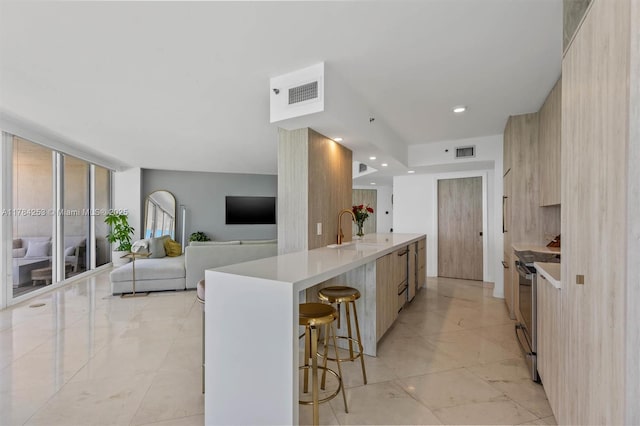 7330 Ocean Ter Unit 20-B, Miami Beach, FL 33141 - kitchen with a sink, visible vents, a kitchen bar, light countertops, and modern cabinets