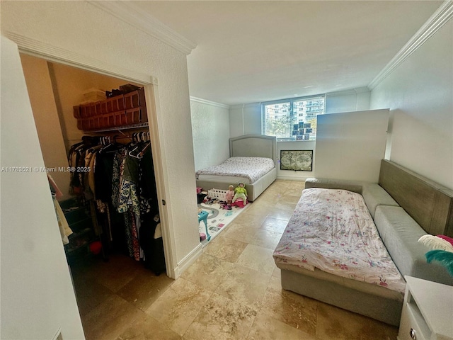 bedroom with a closet, ornamental molding, and a walk in closet