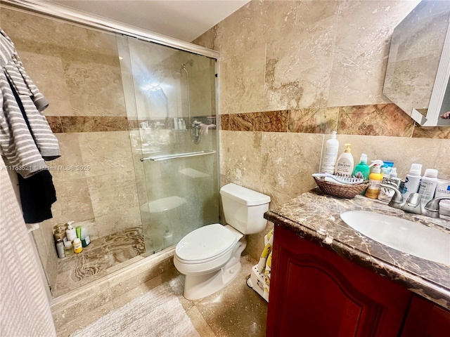 full bathroom with toilet, vanity, a shower stall, and tile walls