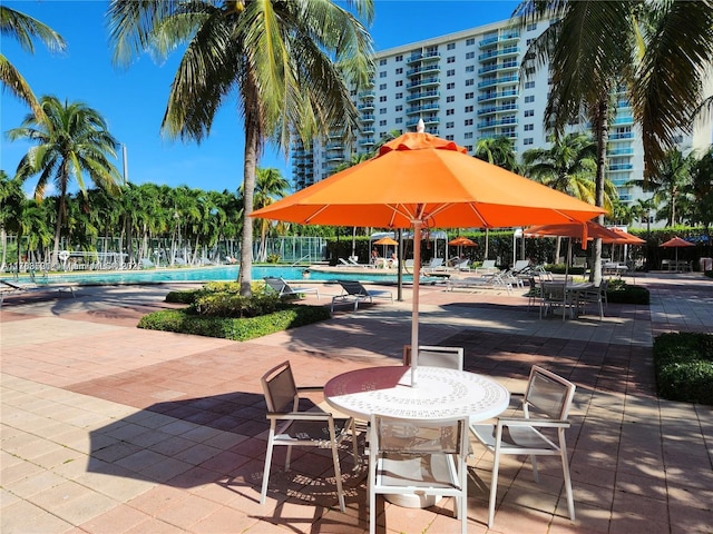 surrounding community with a patio area, a pool, and fence