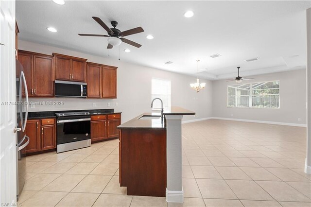 19726 Tesoro Way, Estero, FL 33967 - kitchen with dark countertops, appliances with stainless steel finishes, a sink, ceiling fan with notable chandelier, and light tile patterned flooring