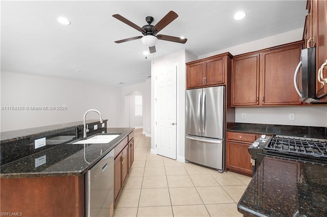 19726 Tesoro Way, Estero, FL 33967 - kitchen featuring ceiling fan, arched walkways, a sink, stainless steel appliances, and light tile patterned flooring