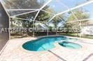 19726 Tesoro Way, Estero, FL 33967 - indoor pool featuring a sink, a patio, a lanai, and a jacuzzi