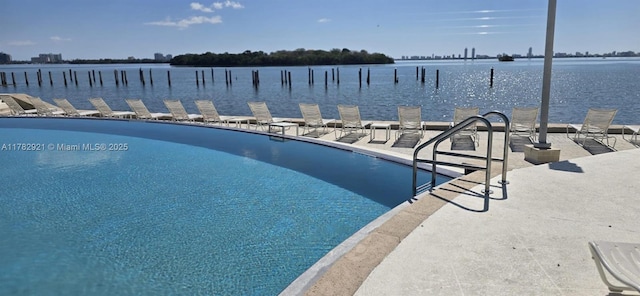 view of swimming pool featuring a water view and a boat dock