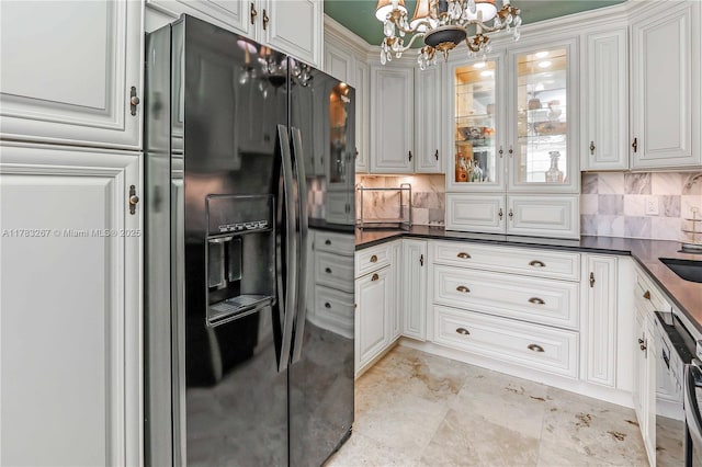 1811 Jefferson St Unit 203, Hollywood, FL 33020 - kitchen with black fridge, a chandelier, dark countertops, decorative backsplash, and white cabinetry