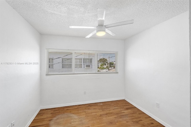 unfurnished room with a textured ceiling, light wood finished floors, baseboards, and a ceiling fan