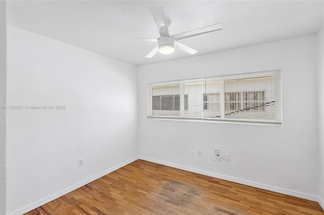 empty room featuring light wood-style flooring, baseboards, a ceiling fan, and plenty of natural light