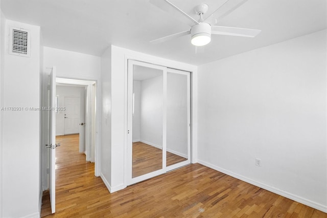 unfurnished bedroom with a closet, visible vents, light wood-type flooring, and baseboards