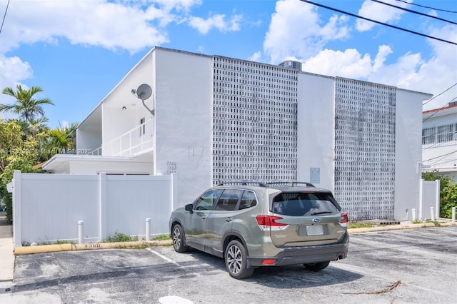 exterior space featuring uncovered parking and fence