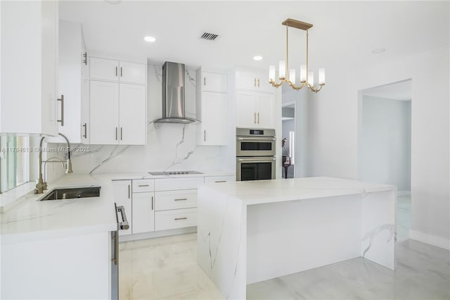 kitchen featuring visible vents, wall chimney exhaust hood, black electric cooktop, a sink, and stainless steel double oven