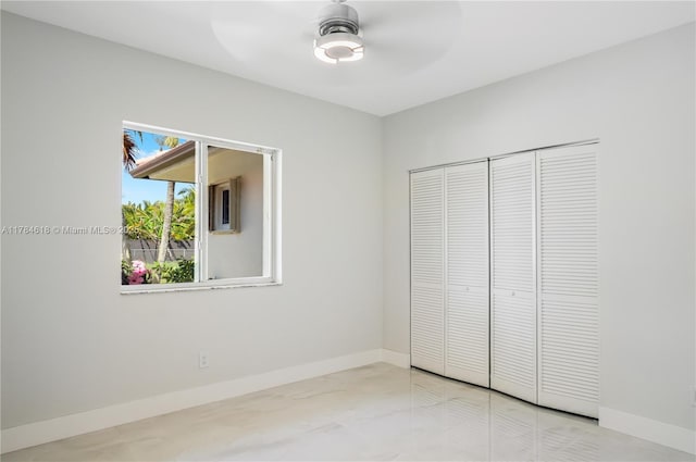 unfurnished bedroom with a closet, baseboards, and a ceiling fan