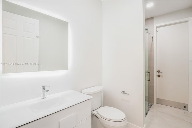 full bathroom with a shower stall, vanity, baseboards, and toilet