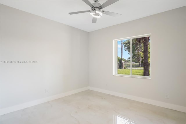 spare room with baseboards, ceiling fan, and marble finish floor