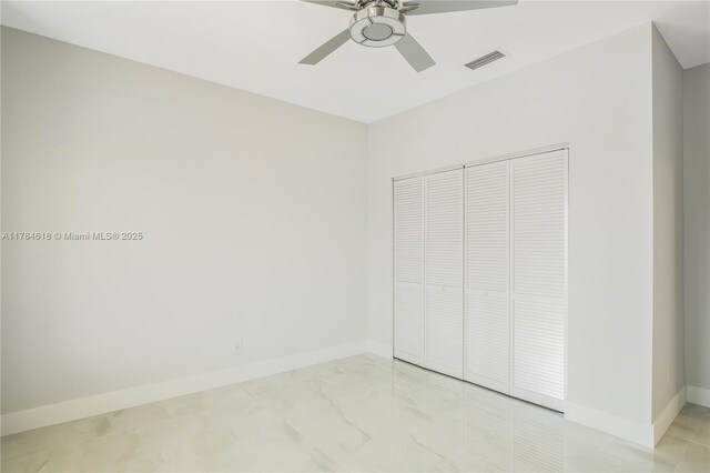 unfurnished bedroom featuring marble finish floor, visible vents, baseboards, and ceiling fan