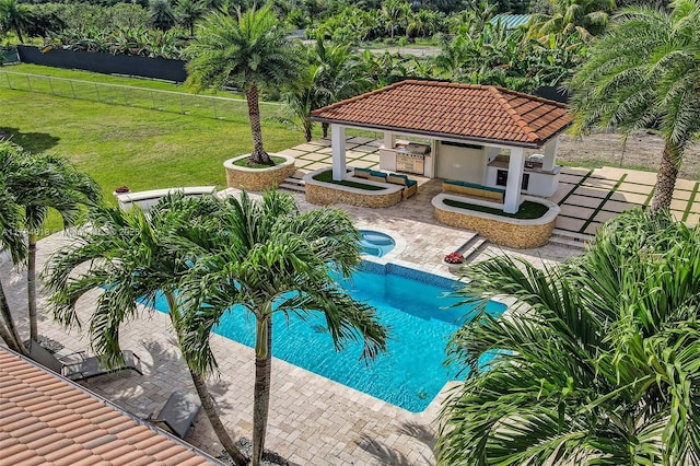 pool featuring an in ground hot tub, fence, a patio, and a lawn