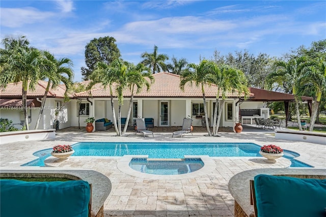 view of swimming pool featuring a pool with connected hot tub, a patio, and outdoor dry bar