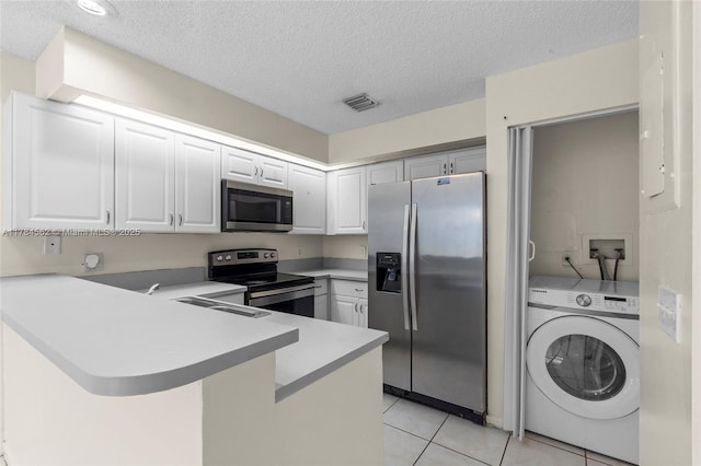 1903 Players Pl, North Lauderdale, FL 33068 - kitchen with appliances with stainless steel finishes, washer / clothes dryer, a peninsula, a textured ceiling, and light tile patterned floors