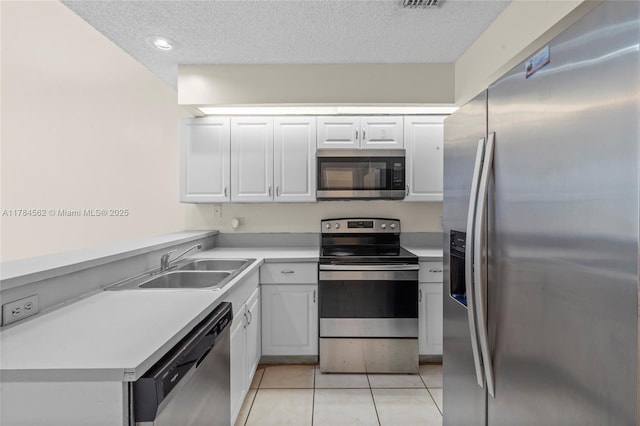 1903 Players Pl, North Lauderdale, FL 33068 - kitchen featuring stainless steel appliances, light tile patterned floors, a textured ceiling, light countertops, and white cabinetry