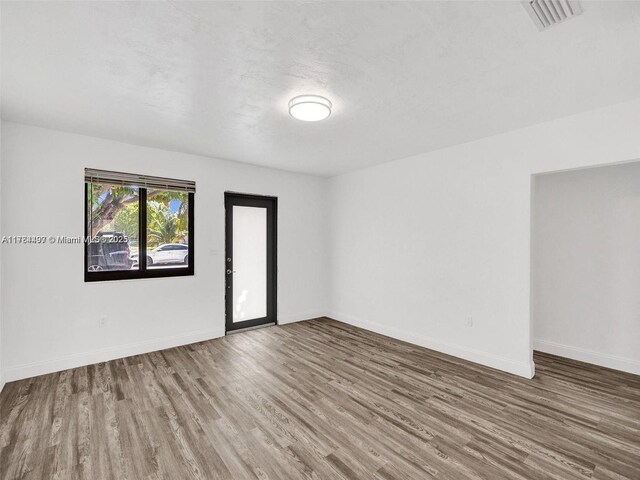 1021 NE 110th St, Biscayne Park, FL 33161 - empty room featuring visible vents, baseboards, and wood finished floors