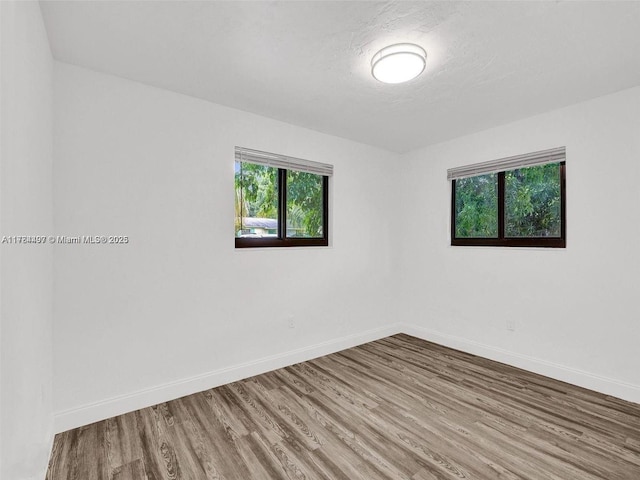 1021 NE 110th St, Biscayne Park, FL 33161 - spare room with a healthy amount of sunlight, baseboards, and wood finished floors