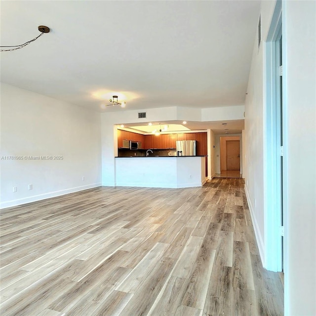 14951 Royal Oaks Ln Unit 203, North Miami, FL 33181 - unfurnished living room with visible vents, light wood-style flooring, and baseboards