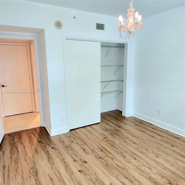 14951 Royal Oaks Ln Unit 203, North Miami, FL 33181 - unfurnished bedroom with an inviting chandelier, a closet, visible vents, wood finished floors, and baseboards