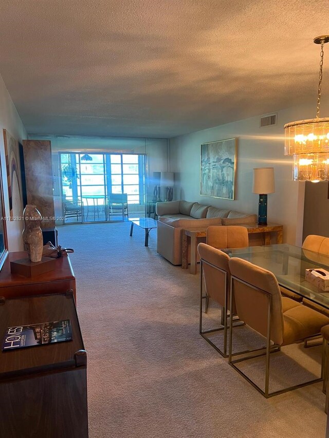 3102 Portofino Pt Unit M2, Coconut Creek, FL 33066 - living room with a textured ceiling, carpet flooring, and a chandelier