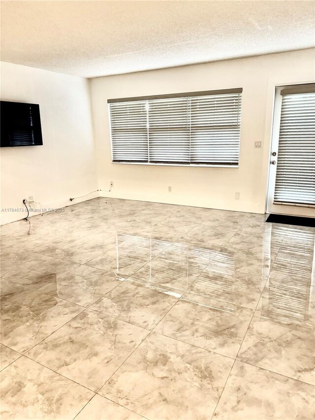900 Atlantic Shores Blvd Unit 126, Hallandale Beach, FL 33009 - empty room featuring a textured ceiling and tile patterned flooring