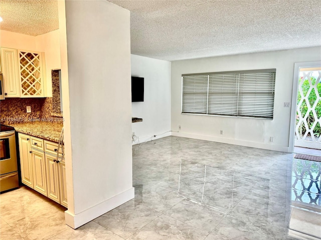 900 Atlantic Shores Blvd Unit 126, Hallandale Beach, FL 33009 - kitchen featuring a textured ceiling, stainless steel electric range oven, decorative backsplash, cream cabinetry, and light marble finish flooring