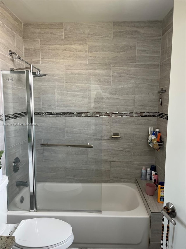 full bathroom featuring toilet and combined bath / shower with glass door