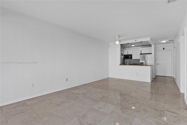 677 NE 24th St Unit 504, Miami, FL 33137 - unfurnished living room with ceiling fan and baseboards