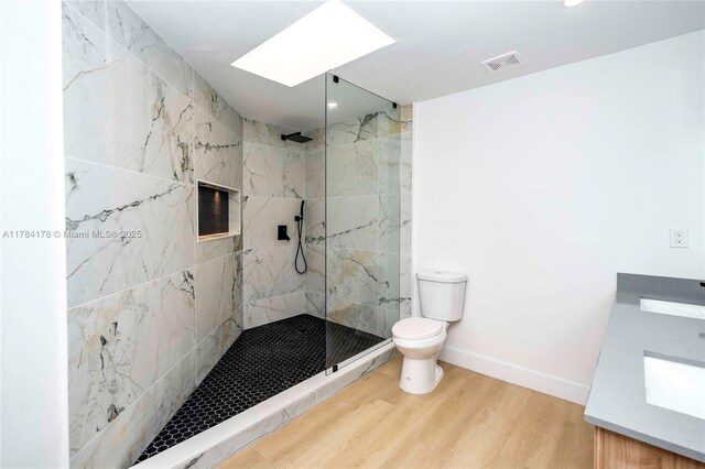 13912 SW 103rd Ln, Miami, FL 33186 - bathroom featuring toilet, a skylight, wood finished floors, a marble finish shower, and baseboards