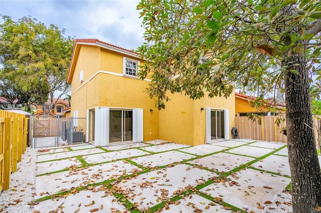 13912 SW 103rd Ln, Miami, FL 33186 - back of house featuring central air condition unit, stucco siding, a gate, a patio area, and fence