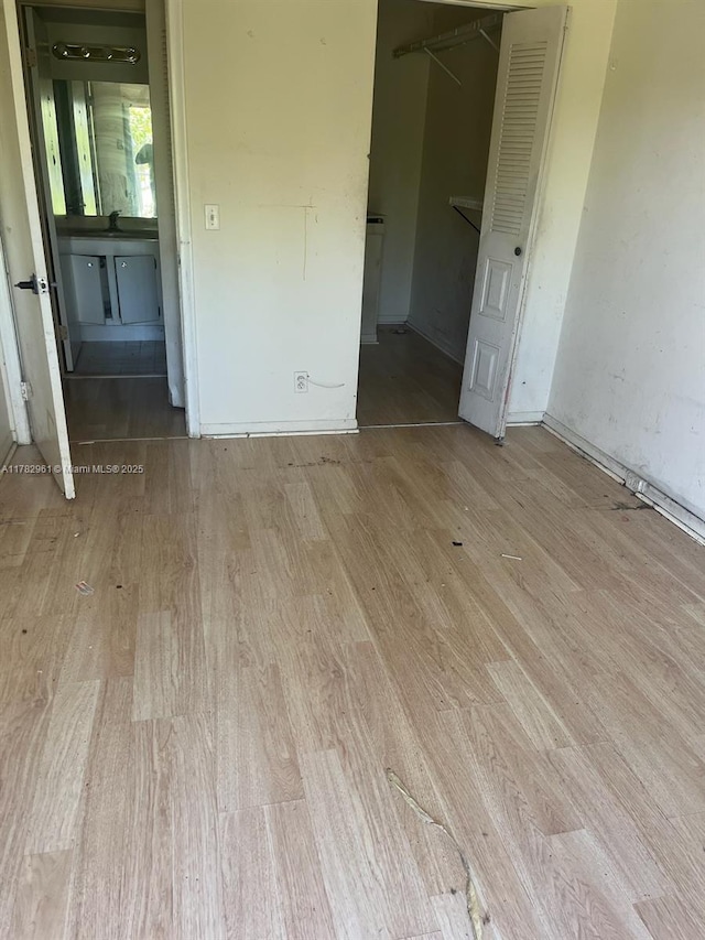 unfurnished bedroom with wood finished floors, a closet, and baseboards