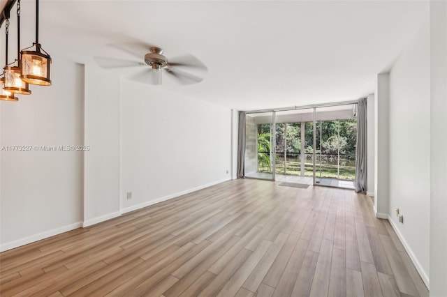 101 Royal Park Dr Unit 1D, Oakland Park, FL 33309 - unfurnished room featuring a wall of windows, ceiling fan, wood finished floors, and baseboards