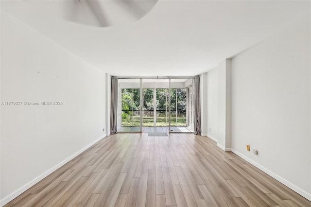 101 Royal Park Dr Unit 1D, Oakland Park, FL 33309 - unfurnished room with light wood-style flooring, baseboards, and a wall of windows