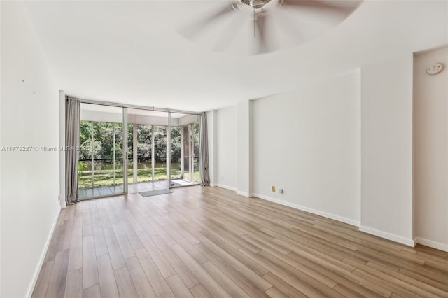101 Royal Park Dr Unit 1D, Oakland Park, FL 33309 - empty room with expansive windows, baseboards, a ceiling fan, and wood finished floors