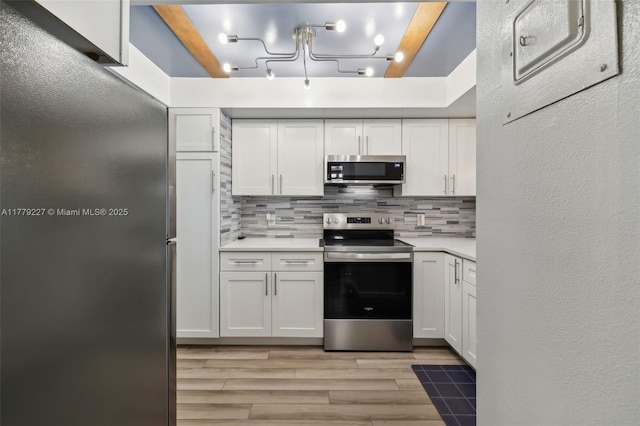 101 Royal Park Dr Unit 1D, Oakland Park, FL 33309 - kitchen with light countertops, light wood finished floors, white cabinetry, stainless steel appliances, and backsplash