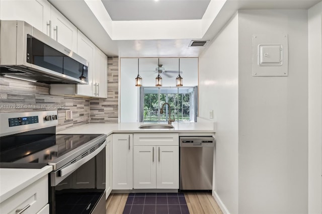 101 Royal Park Dr Unit 1D, Oakland Park, FL 33309 - kitchen with visible vents, a sink, appliances with stainless steel finishes, white cabinetry, and decorative backsplash