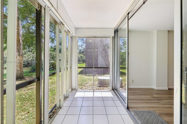 101 Royal Park Dr Unit 1D, Oakland Park, FL 33309 - unfurnished sunroom with tile patterned floors, baseboards, and a healthy amount of sunlight